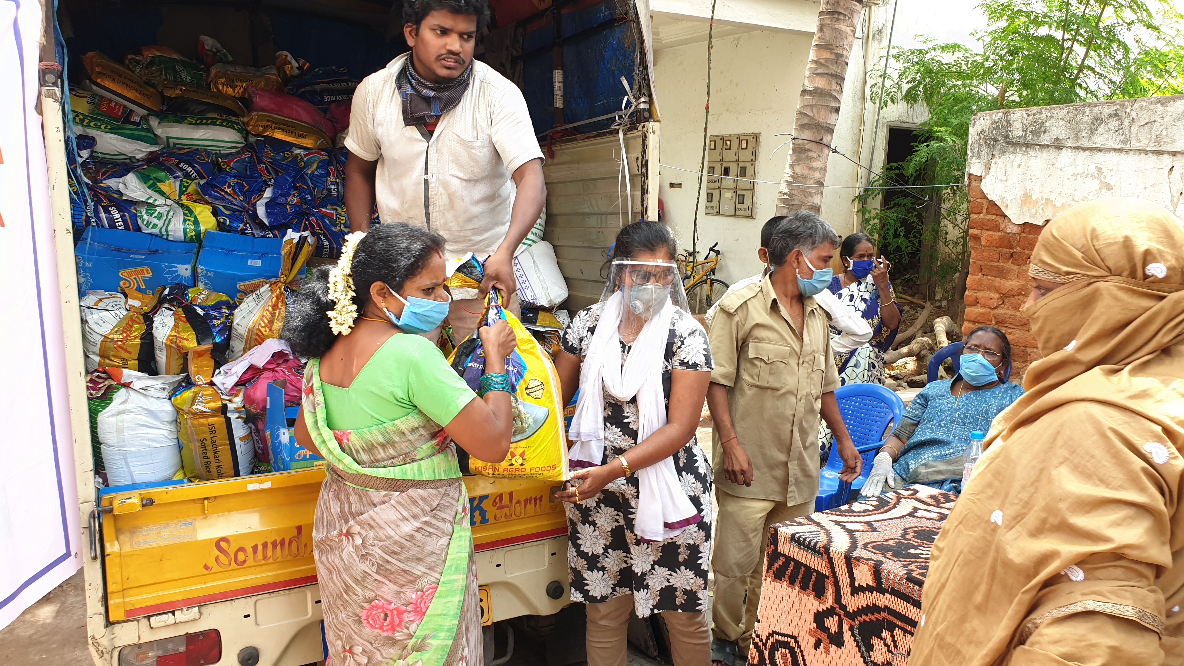 Aus einem Laster werden Hilfsgüter an Bedürftige in den Slums von Bangalore verteilt.verteilt